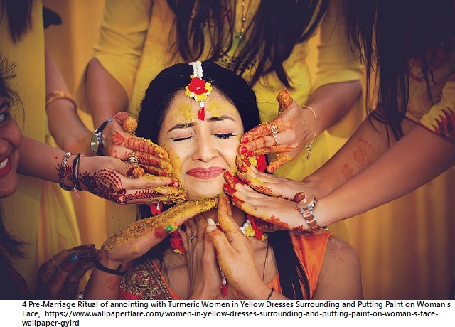 4 women-in-yellow-dresses-surrounding-and-putting-paint-on-woman-s-face